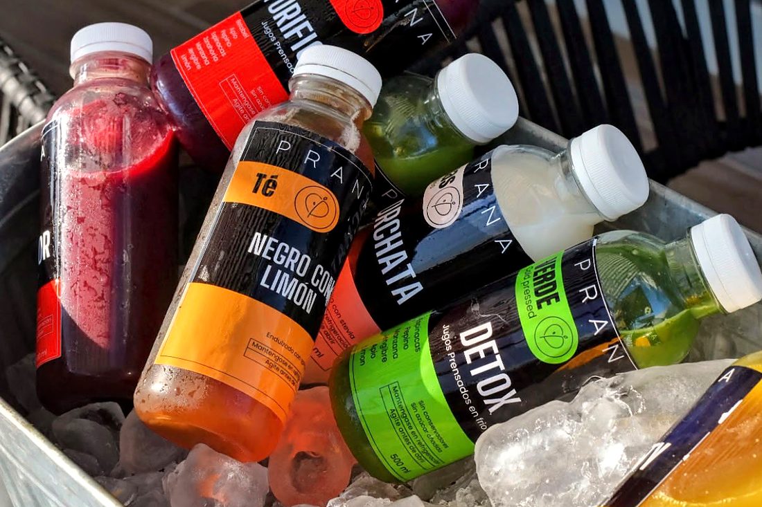 Botellas de jugos prensados en frío, horchata y té negro con limón sobre hielo