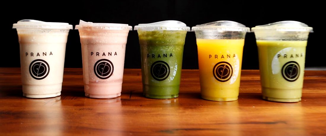 Cinco vasos Prana con licuados y smoothies de distintos colores